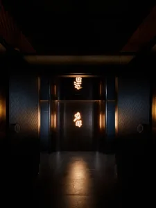 牆面飾有東方文字的玻璃門昏暗電梯，沐浴在溫暖黃光中
