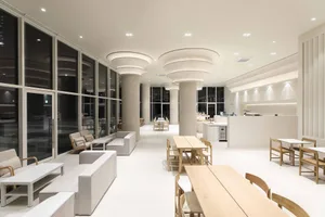 A modern restaurant space with white walls, chairs, and dining tables, featuring inviting and comfortable seating options