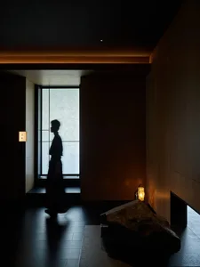 A traditional hallway with a wooden appearance, featuring two people walking down the hall