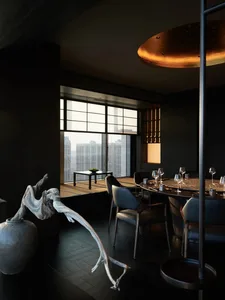 Elegant dining space with a large window, table set with fine china and wine glasses, and multiple chairs for guests