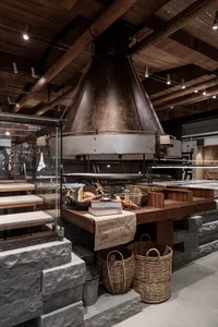 Warm and inviting restaurant interior with a central oven, books, and a cozy atmosphere