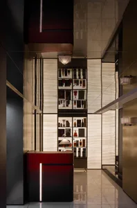 Modern showroom with a red countertop display case featuring bottles, surrounded by stylish surroundings