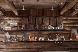 A cluttered wooden interior with books and cups displayed on shelves, creating a cozy and lived-in atmosphere
