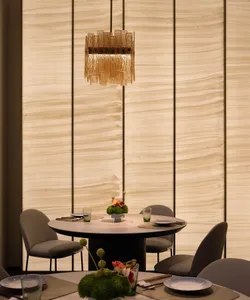 Elegant dining area with a round table, chairs, and a vase, set in a well-lit room with a modern and inviting atmosphere