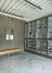 A modern bookshelf with glass shelves and decorative bowls, creating an inviting atmosphere for reading and relaxation
