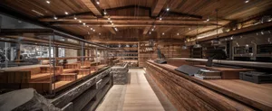 Warm and inviting interior space with wooden floors and walls, featuring tables and chairs for dining