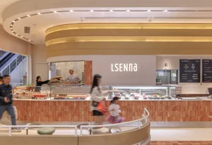 Casual Scandinavian cafe with a brick wall, a cafeteria area, and people walking around