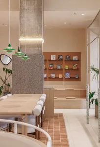 A calm and inviting bookstore interior with wooden floors, white walls, and bookshelves, featuring multiple chairs for seating and a focus on reading and relaxation