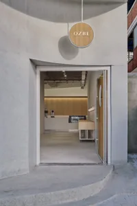 Spacious kitchen dining area with wooden floors, two sinks, a refrigerator, and modern design