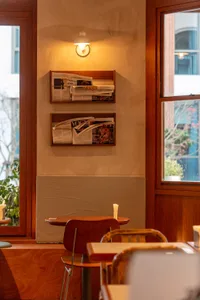 A modern dining area with chairs around a table, bookshelves in the background, and a cozy atmosphere