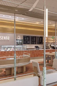 Warm and inviting Italian restaurant with a modern twist, featuring a counter with displayed food, natural light, and comfortable seating