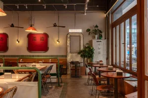 A restaurant interior with wooden tables and chairs, creating a warm and inviting atmosphere for dining and socializing