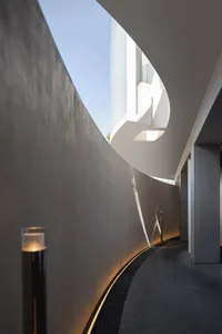 A modern interior space with two staircases, one on each side, creating a sense of depth and movement