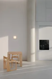 Empty white room with a wooden table and two chairs, creating a calm and minimalistic atmosphere