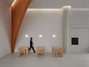 A modern showroom with white walls, multiple dining tables, and chairs, creating a welcoming atmosphere for visitors to explore various table designs