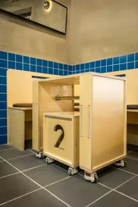 Bathroom with two sinks, wooden cabinets, and tiled walls and floors, featuring a clean and modern appearance