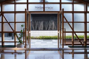 Bright and inviting interior space with a glass doorway, metal frame, and potted plants, flooded with natural light