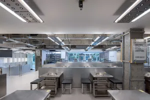 Modern kitchen with stainless steel counters, large countertop, and various bowls placed throughout the space