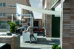 Casual outdoor dining space with a white countertop, chairs, and umbrellas, set amidst a restaurant atmosphere