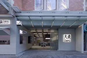 開放式辦公空間配有玻璃門、現代家具與壁掛電視，充滿椅子與桌椅，明亮且溫馨的氛圍