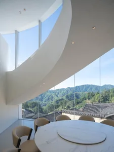 Dining room with a large window offering a panoramic view, wooden chairs, and a dining table