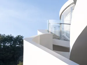 A modern staircase with concrete steps in a well-lit, minimalist stairwell