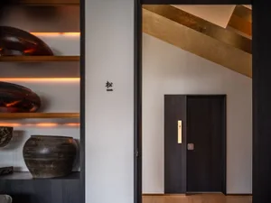 A clean and modern hallway with a white wall, two doors, and well-lit space