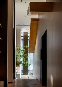 A bright and welcoming hotel lobby with a large window, two potted plants, and a sense of openness