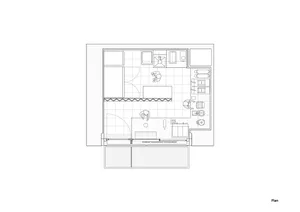 Empty minimalist room with white walls, several chairs, and a dining table, giving a sense of spaciousness and functionality