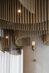 A stylish and inviting space with a large metal sculpture, a lamp, and well-lit ambiance, possibly from natural or artificial light sources