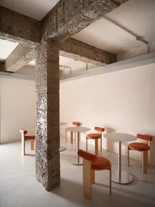 Empty modern restaurant interior with multiple dining tables and chairs, clean and well-organized, ready for customers
