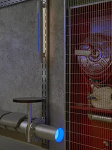 Industrial workspace with a red door, metal gate, clocks, and a chair in a dimly lit area