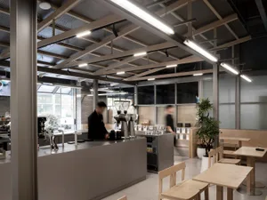 Open dining area with multiple tables, benches, and chairs, well-lit with natural and artificial light, inviting atmosphere