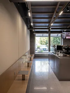 Bright and welcoming cafe with dining tables, chairs, and natural light from a large window