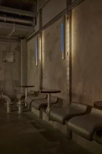 Cozy bar area with wooden benches, stone wall, and warm lighting
