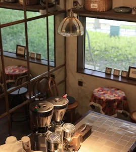 A warm and inviting cafe interior with wood and metal elements, featuring multiple seating areas and tables