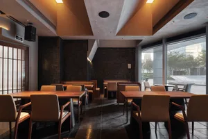 A well-lit restaurant with wooden tables and chairs, inviting atmosphere, and natural light from windows