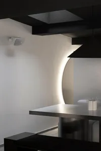 A modern kitchen with two sinks, a countertop, and a mirror above, creating a clean and organized atmosphere
