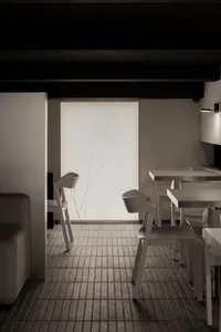 A modern dining space with white tables and chairs, creating a clean and modern atmosphere with ample seating options