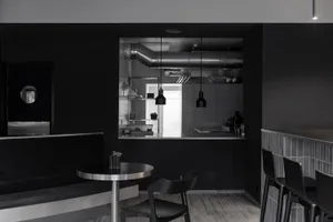 Modern kitchen with a dining table, chairs, and appliances, set against a black background