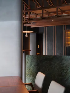 A modern dining space with a wooden dining table and two chairs, surrounded by a well-lit and comfortable atmosphere