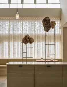 A well-lit kitchen with a dining table and chairs, surrounded by vases and a warm atmosphere