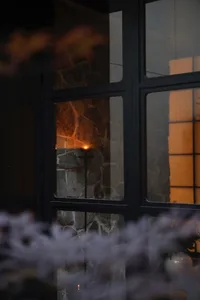 A serene home interior with a glass window and a lit candle creating a warm atmosphere