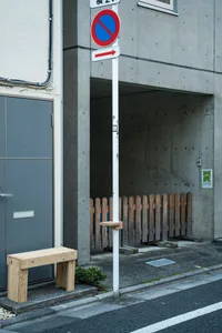 街角設有白色燈柱與紅色招牌，搭配長椅及混凝土與木質元素的混搭