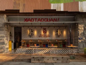 A restaurant with a blend of traditional and modern styles, featuring wooden walls, metal accents, and comfortable seating for guests