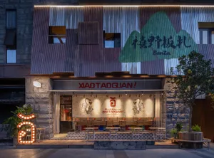 A modern Asian restaurant with a mountain theme, featuring a large dining area with multiple tables, benches, and warm lighting