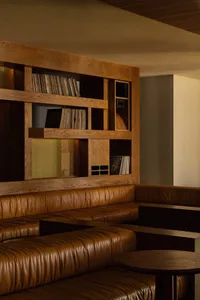 Cozy modern living space with comfortable furniture, well-lit, and a collection of books on various surfaces