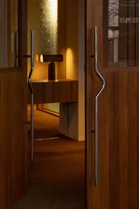 A doorway in a hotel lobby with a wooden frame, carpeted floor, and inviting atmosphere