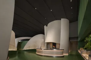Warm and inviting restaurant interior with a large fireplace, white walls, and two sinks near the fireplace