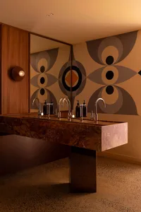 Bathroom with a large marble countertop, two sinks, and bathroom essentials